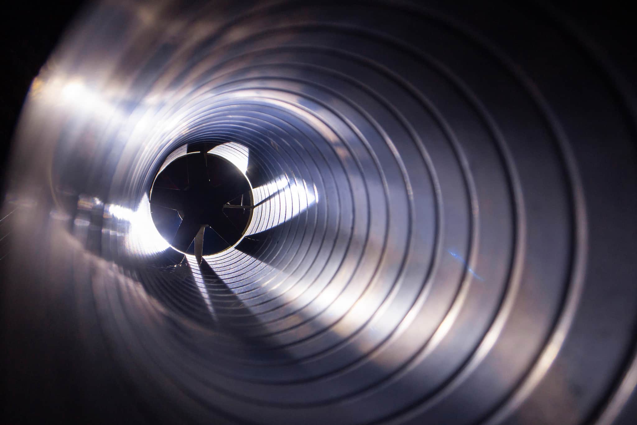 Photo of the inside of a metal cylindrical air duct.